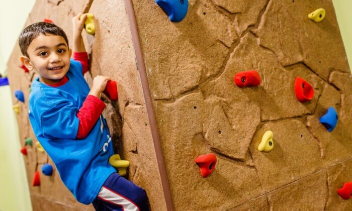 kid climbing on a rock tumbles playground